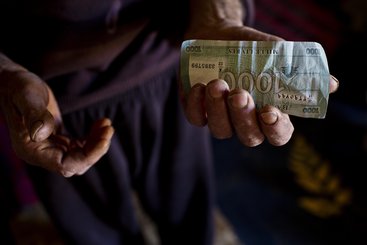 A Syrian refugee in Lebanon holds the money he will use to buy groceries